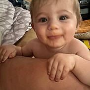 Rippley joined the competition — help win amazing prizes! baby, child, face, hand, arm, indoors, blanket, sofa, furniture, smiling, messy_face, skin, person, shelf, clothing, home, infant, cute, expression, closeup