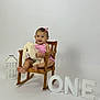 baby, child, rocking_chair, stuffed_animal, bunny, pink_dress, hair_bow, smile, wooden_furniture, lantern, white_background, one, milestone, celebration, cute, portrait, sitting, happy, indoor, person