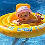 baby, blue, child, cute, floating, fun, hat, inflatable_ring, kid, outdoor, pink, play, pool, summer, sunhat, swimming, toy, vacation, water, yellow