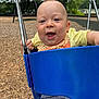 baby, child, swing, playground, smiling, happy, outdoor, park, woodchips, yellow_shirt, blue_swing, shorts, grass, trees, summer, fun, play, person, infant, daylight