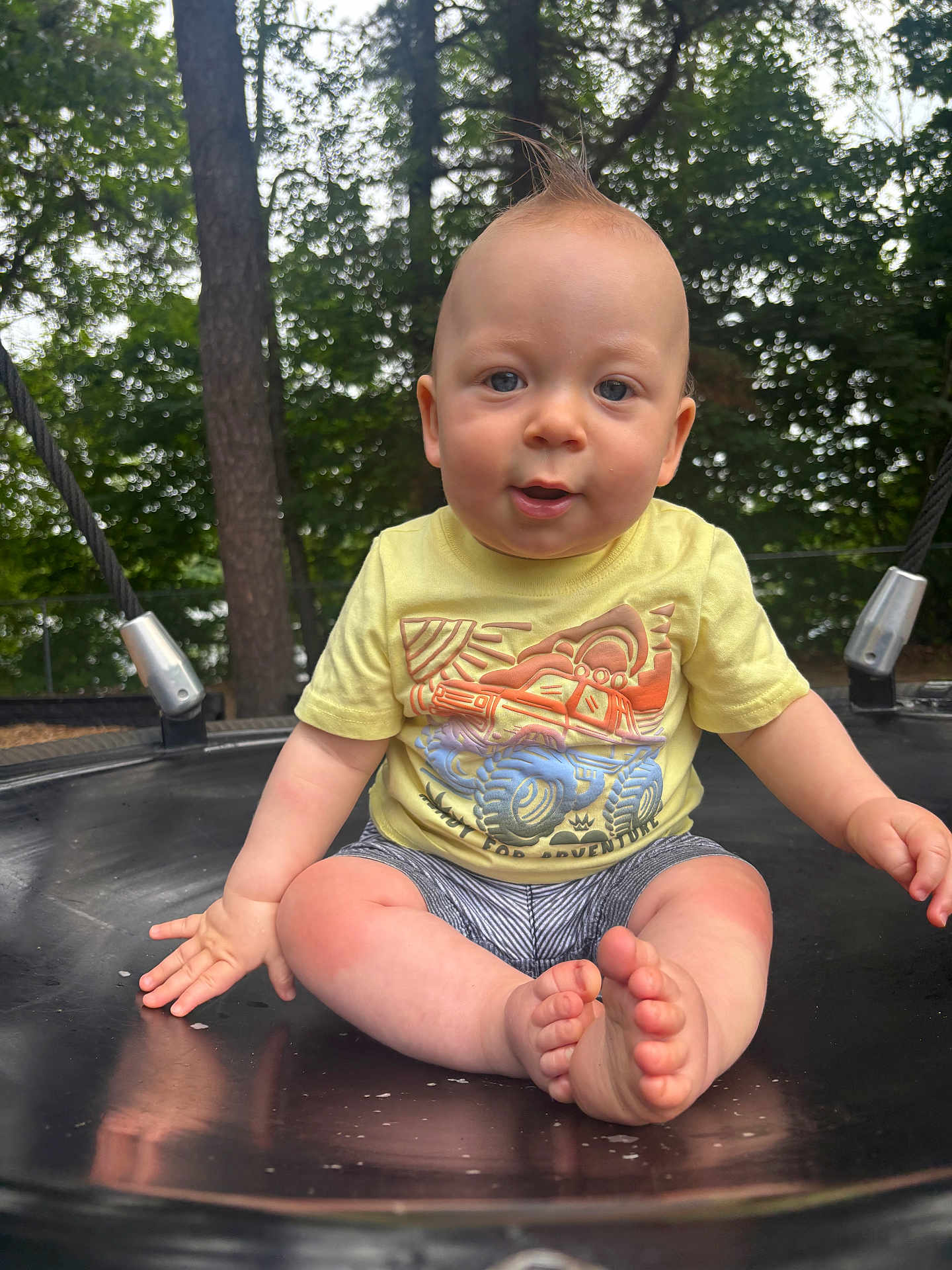 Kevin joined the competition — help win amazing prizes! baby, child, swing, outdoor, forest, trees, yellow_tshirt, shorts, barefoot, playground, smiling, moawk_hairstyle, summer, nature, cute, person, sitting, sunlight, daytime, fun