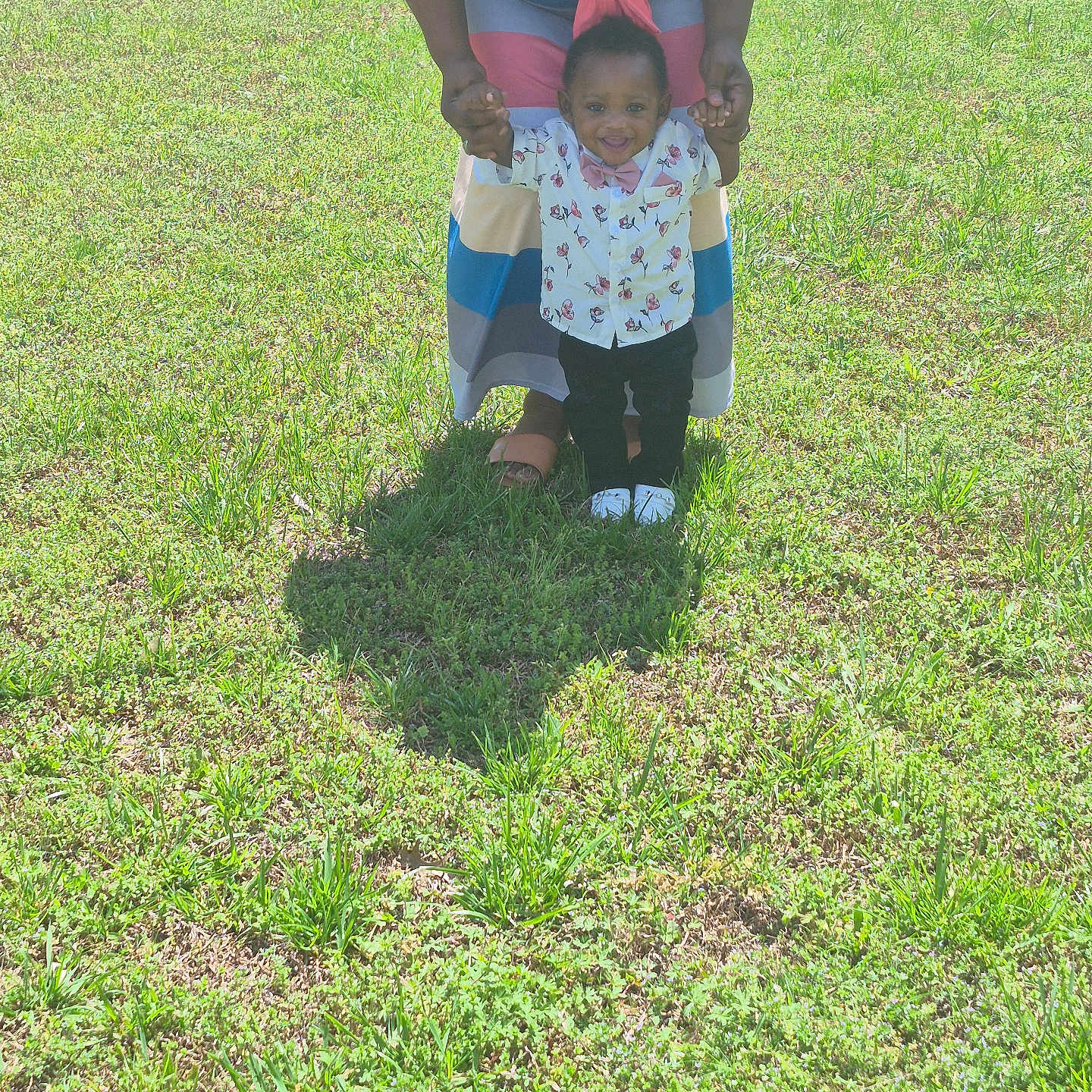 Montrell joined the competition — help win amazing prizes! child, toddler, adult, grass, outdoor, sunlight, smiling, holding_hands, dress, shirt, bow_tie, shadow, happy, standing, greenery, nature, footwear, person, field, support