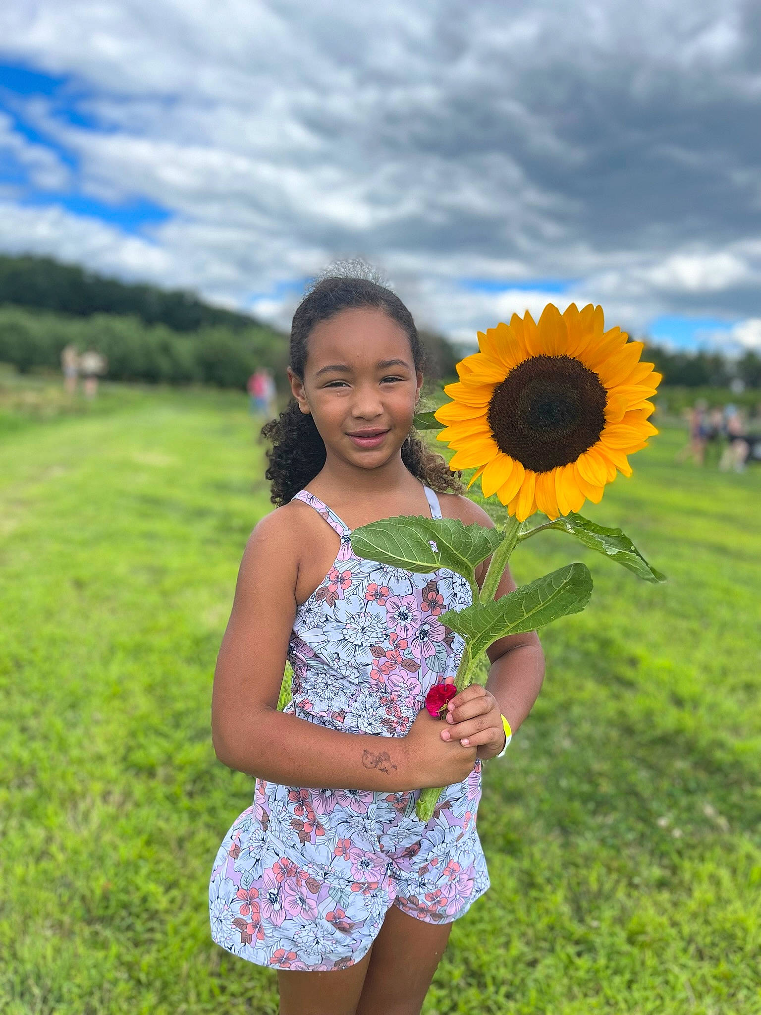 Amaya is registered to the contest to win money with this photo: azure, blue, botany, cloud, day_dress, dress, facial_expression, flash_photography, flower, grass, green, hair, happy, joy, leaf, one_piece_garment, people_in_nature, person, petal, plant