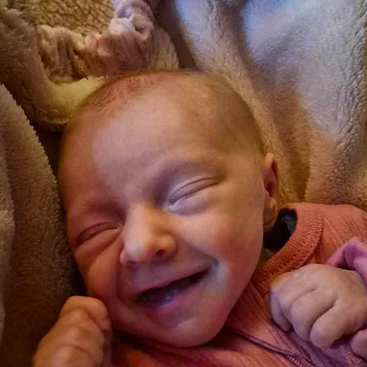 Kali joined the competition — help win amazing prizes! baby, blanket, child, closed_eyes, cozy, cute, face, fist, hands, happy, indoors, infant, newborn, pink_clothing, portrait, resting, sleepy, smiling, soft, warm