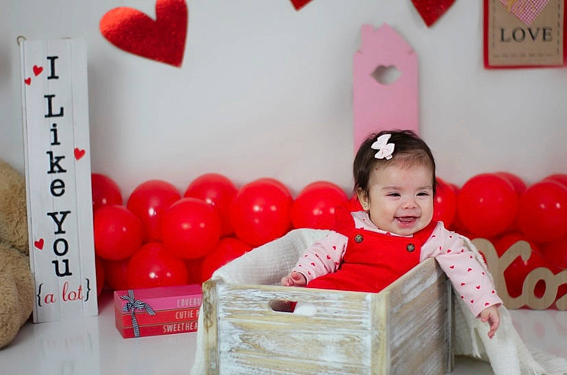Kianna is registered to the contest to win money with this photo: baby, baby_playing_with_toys, baby_toddler_clothing, basket, box, child, event, fun, happy, leisure, magenta, party_supply, person, pink, product, red, room, smile, storage_basket, toddler