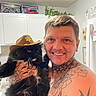 animal_companion, black_cat, cabinets, cat, cowboy_hat, fluffy_cat, home, houseplant, indoors, kitchen, lego, long_hair, man, pet, portrait, selfie, sheriff_hat, smiling, tattoos, whiskers