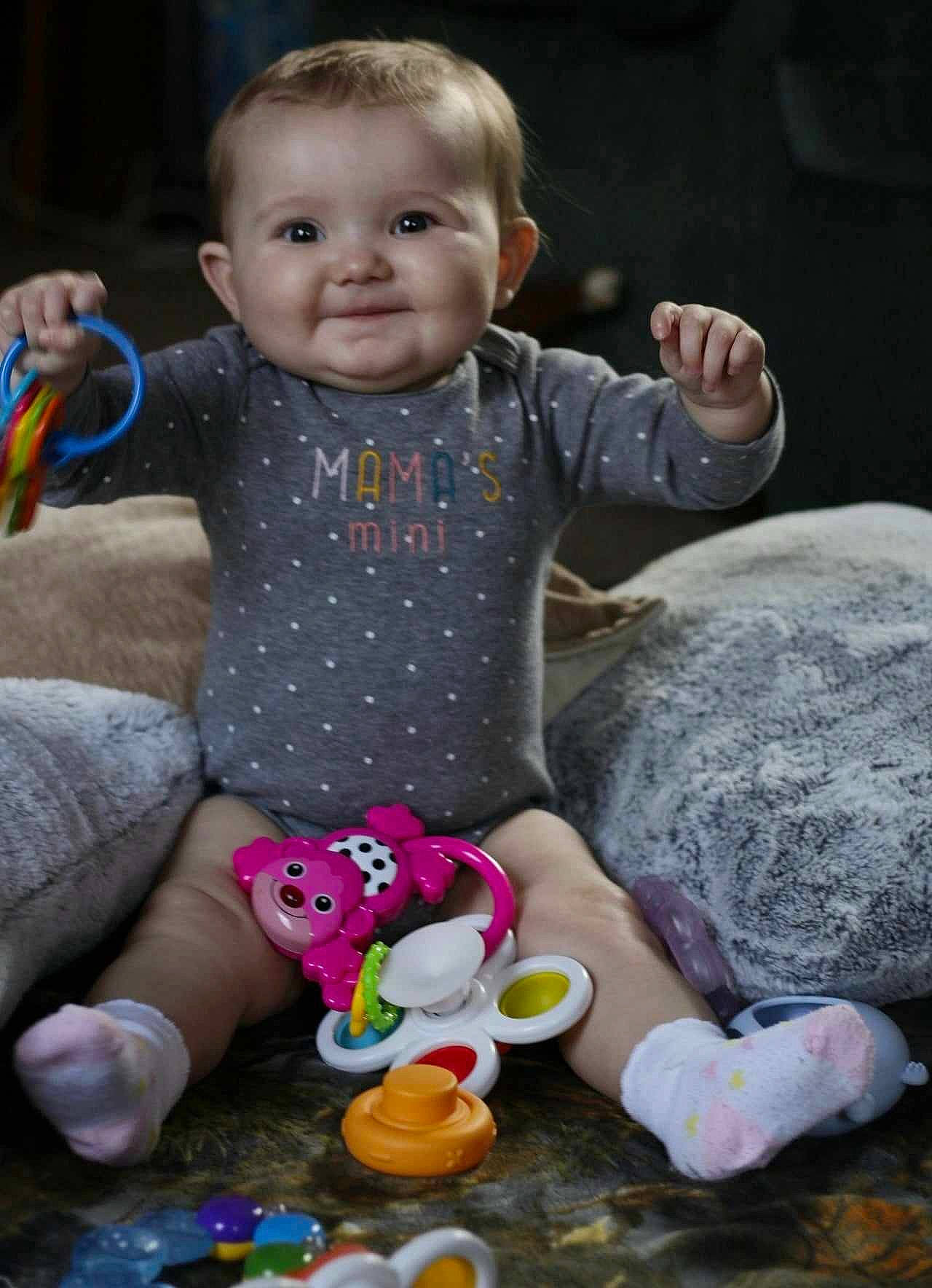 Athena is registered to the contest to win money with this photo: baby, baby_toddler_clothing, cheek, child, fun, happy, human_body, joy, leisure, mammal, people, person, photograph, pink, play, sitting, skin, smile, snapshot, toddler