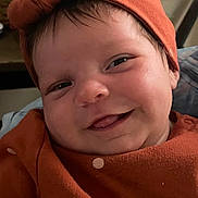 Aziyah is registered to the contest to win money with this photo: apparel, baby, child, closeup, cute, eyes, face, happy, headband, headwear, indoors, infant, mouth, orange_clothing, person, polka_dots, portrait, skin, smiling, tongue