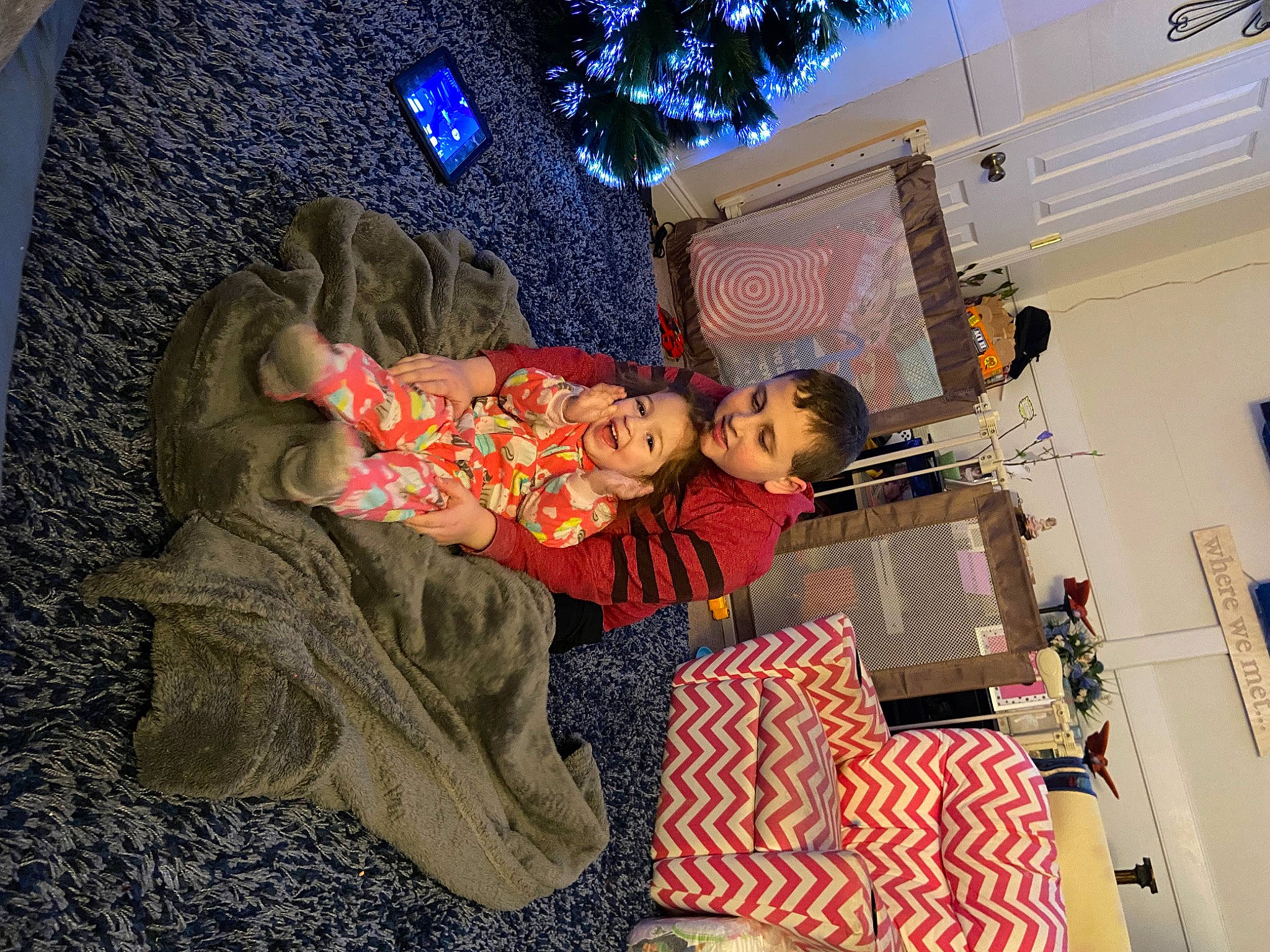Timothy joined the competition — help win amazing prizes! blanket, child, christmas_eve, comfort, event, fun, holiday, leisure, linens, living_room, orange, pattern, person, room, sitting, thread, toddler, toy, tree, visual_arts