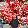 child, boy, balloons, valentines_day, heart_shaped, red, store, holiday, celebration, smiling, party, decorations, indoor, shopping, festive, young, cute, happy, person, casual_clothing