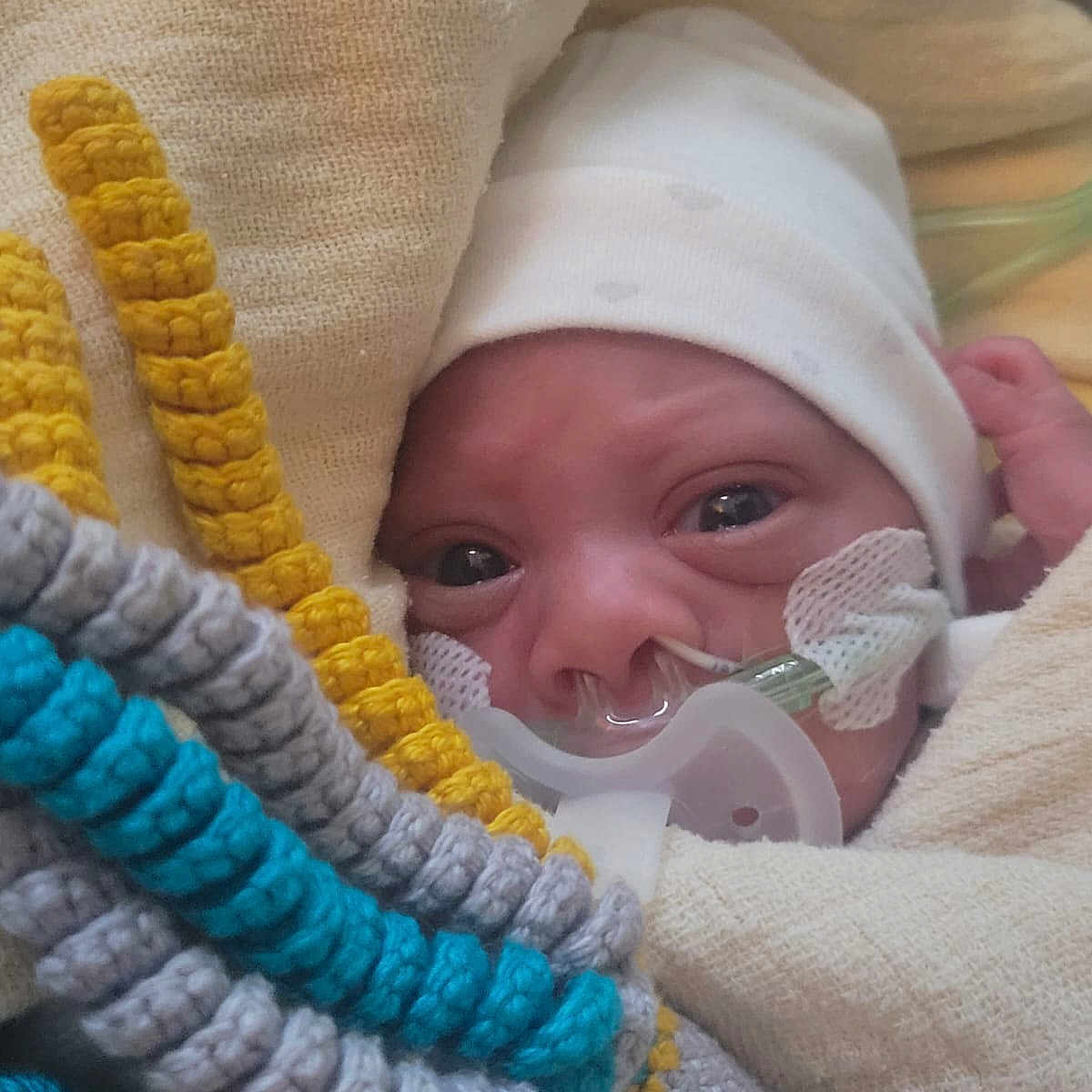 Siraj a rejoint le concours — aidez-le/la à gagner de superbes lots ! baby, blanket, blue, child, closeup, cozy, crochet, eyes, face, gray, hat, hospital, infant, knitted_toy, medical, nasal_cannula, newborn, oxygen_tube, wrapped, yellow