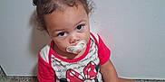 Nakaylia joined the competition — help win amazing prizes! toddler, child, pacifier, pigtails, carpet, sitting, minnie_mouse, shirt, red, white, wall, indoor, curious, baby, person, cute, looking_up, hair, skin, feet