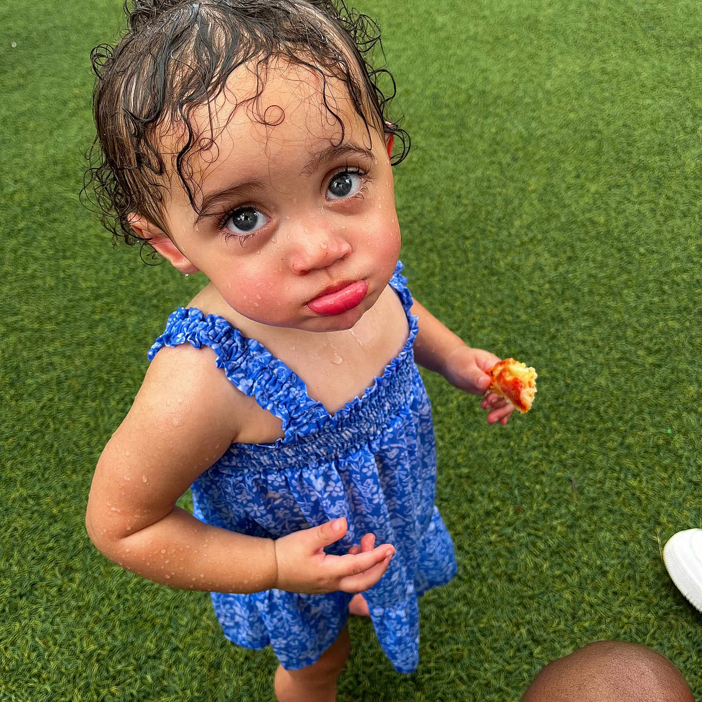 Kmayrah is registered to the contest to win money with this photo: barefoot, blue_dress, child, curly_hair, cute, expression, food, grass, looking_up, outdoor, person, pizza, playful, pout, skin, small_hand, standing, summer, toddler, wet_hair