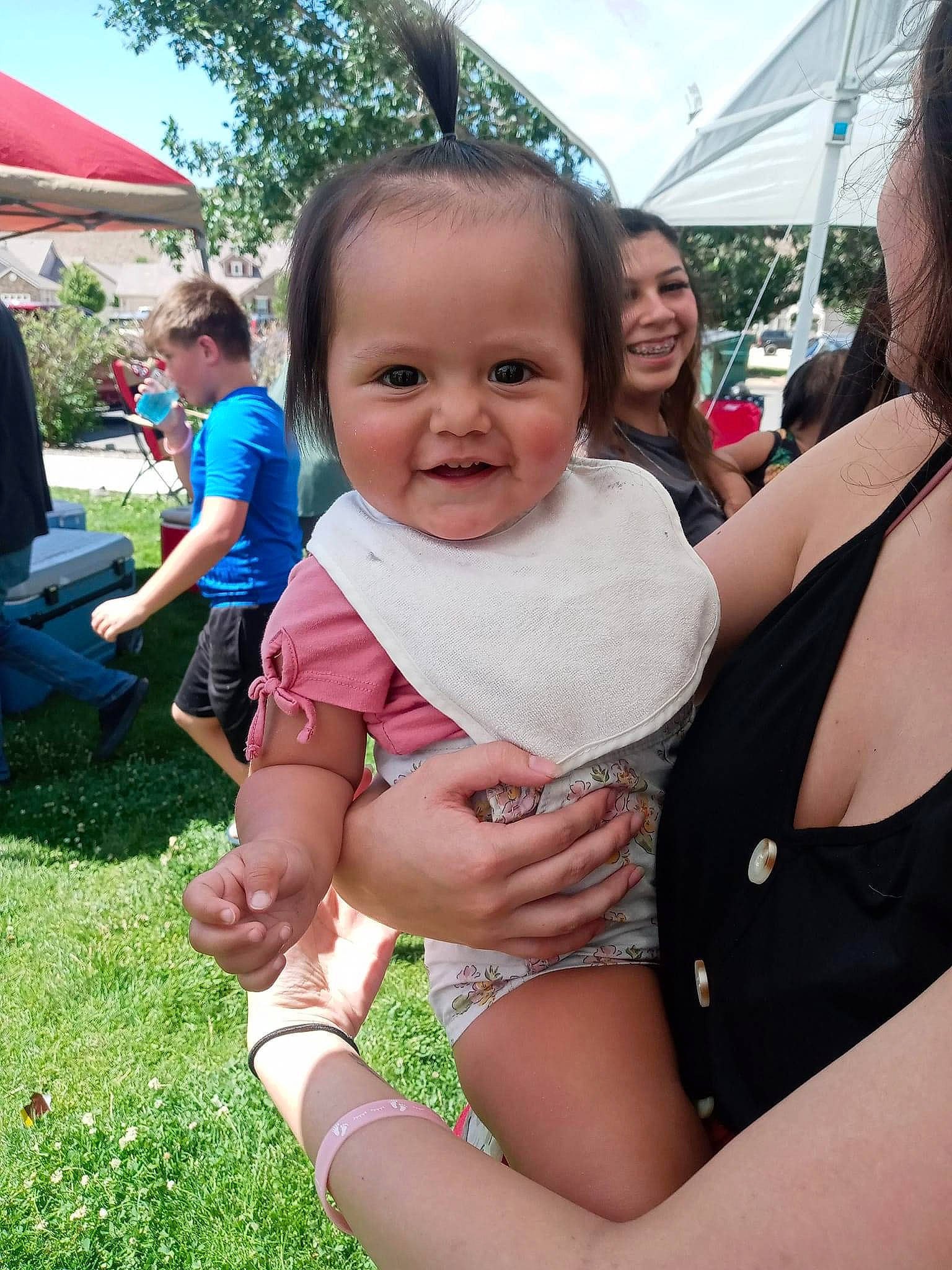 Brianna is registered to the contest to win money with this photo: community, daytime, eye, facial_expression, gesture, grass, happy, head, interaction, joy, leaf, leisure, mammal, person, plant, shorts, skin, sky, smile, social_group