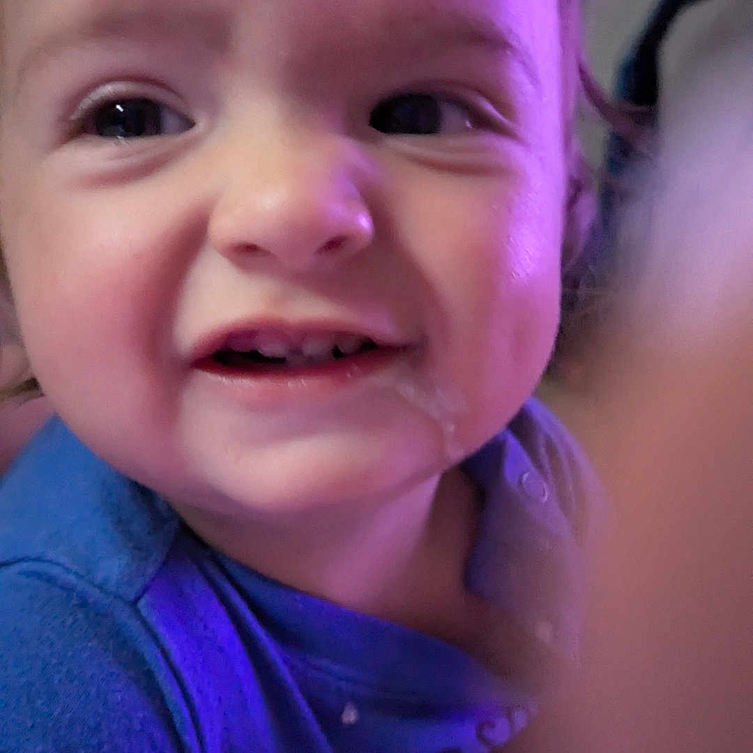 Ryder joined the competition — help win amazing prizes! baby, child, infant, smiling, face, portrait, close_up, indoor, purple_lighting, blue_clothing, baby_clothing, sitting, cuddling, adult, arm, hand, bed, happy, selfie, photography