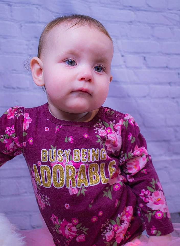 Aspen is registered to the contest to win money with this photo: arm, baby_toddler_clothing, cheek, chin, eye, face, facial_expression, hair, hairstyle, head, lip, neck, nose, outerwear, person, product, purple, shirt, skin, sleeve