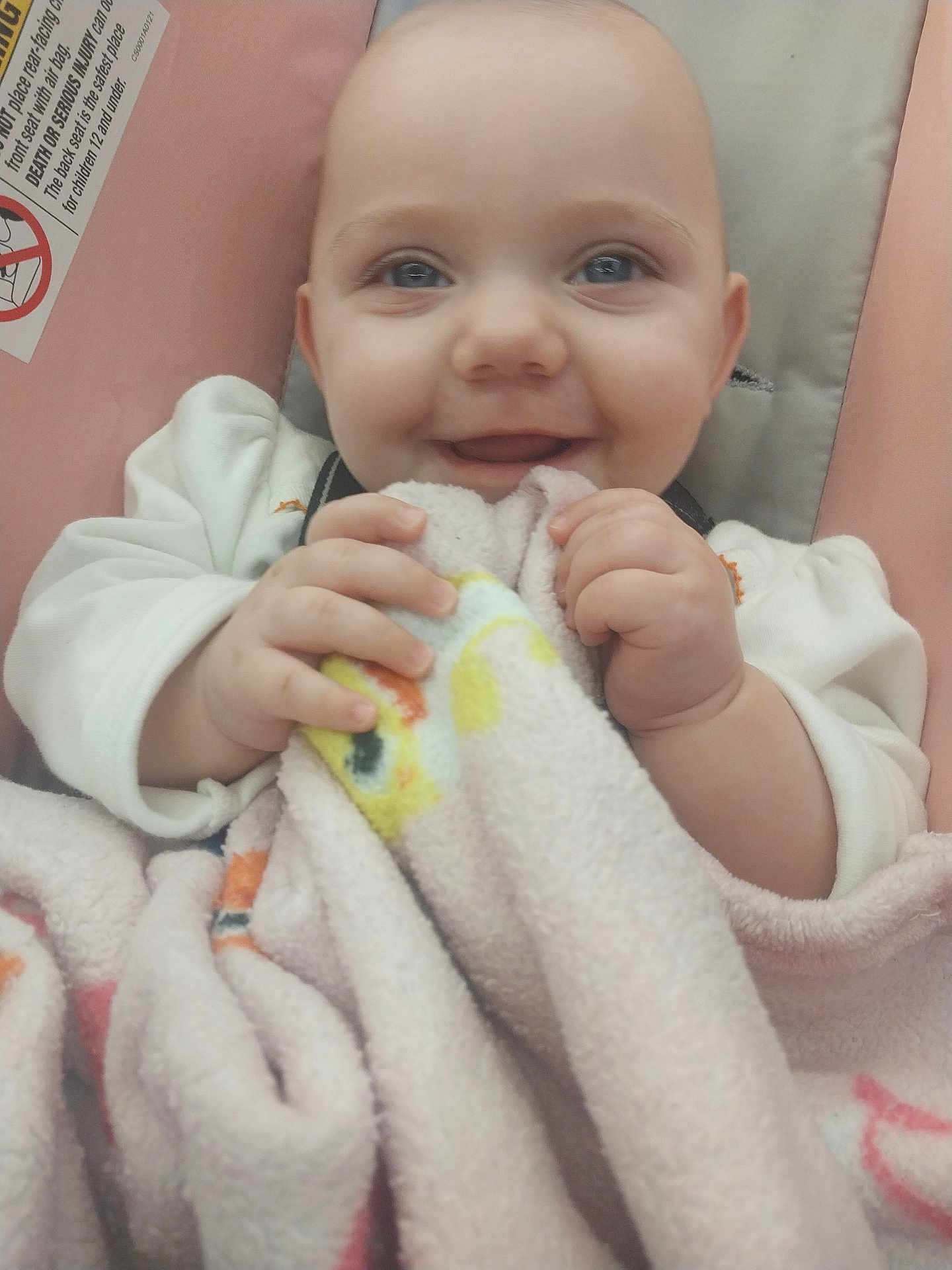 Emberlynn joined the competition — help win amazing prizes! baby, blanket, blue_eyes, cushion, cute, face, hands, infant, joyful, light_skin, looking_at_camera, person, pink, portrait, seat, smiling, soft_texture, white_clothing, wrapped, young_child