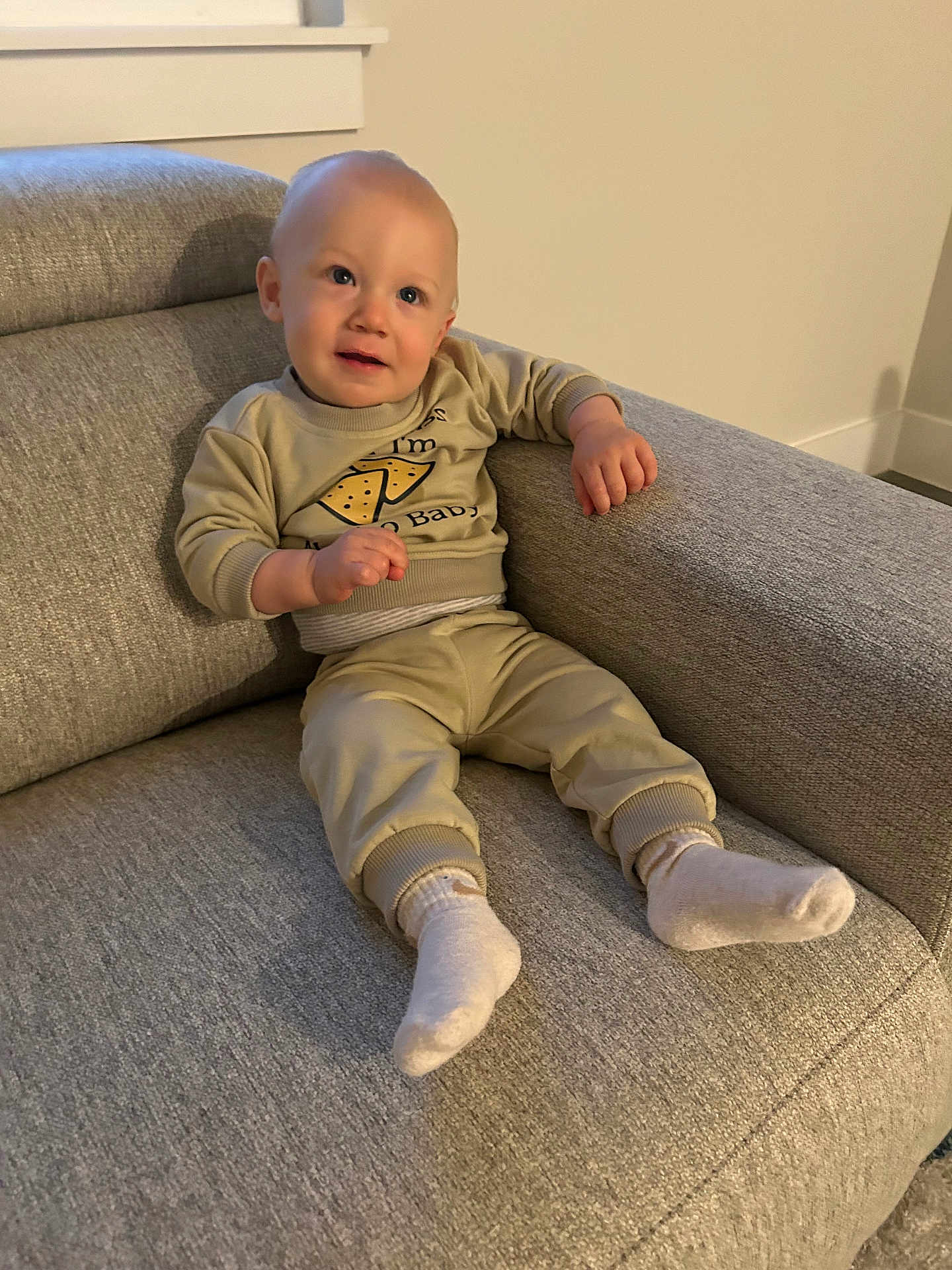 Lincoln joined the competition — help win amazing prizes! toddler, child, couch, gray_couch, socks, beige_clothing, sitting, indoor, window, curious_expression, short_hair, baby, furniture, relaxed, wall, floor, cozy, casual, portrait, home