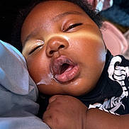 Miyonni Rose is registered to the contest to win money with this photo: baby, sleeping, drool, close_up, face, hand, infant, skin, curly_hair, peaceful, nap, black_clothing, soft_light, indoor, child, portrait, resting, cute, young_child, relaxed