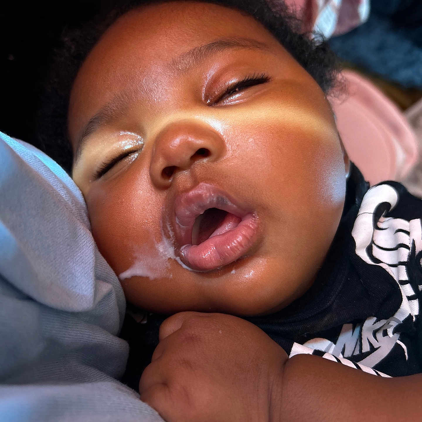 Miyonni Rose is registered to the contest to win money with this photo: baby, black_clothing, child, close_up, curly_hair, cute, drool, face, hand, indoor, infant, nap, peaceful, portrait, relaxed, resting, skin, sleeping, soft_light, young_child