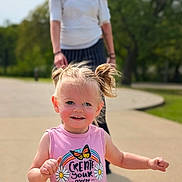 Presleigh joined the competition — help win amazing prizes! toddler, child, smiling, outdoor, sunny, pigtails, pink_shirt, text_on_clothing, adult, blurred_background, pathway, greenery, daylight, person, happy, casual_clothing, portrait, nature, playful, cute