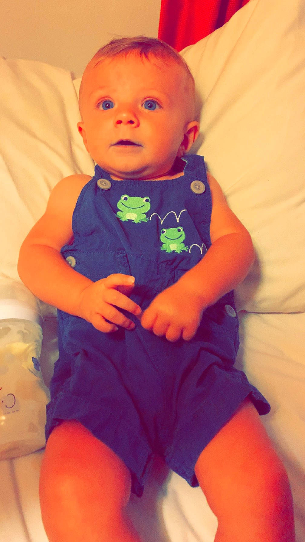 Joshua is registered to the contest to win money with this photo: baby, baby_toddler_clothing, cheek, child, comfort, electric_blue, eye, happy, human_leg, iris, nail, orange, person, pink, purple, red, sitting, skin, sleeve, thigh