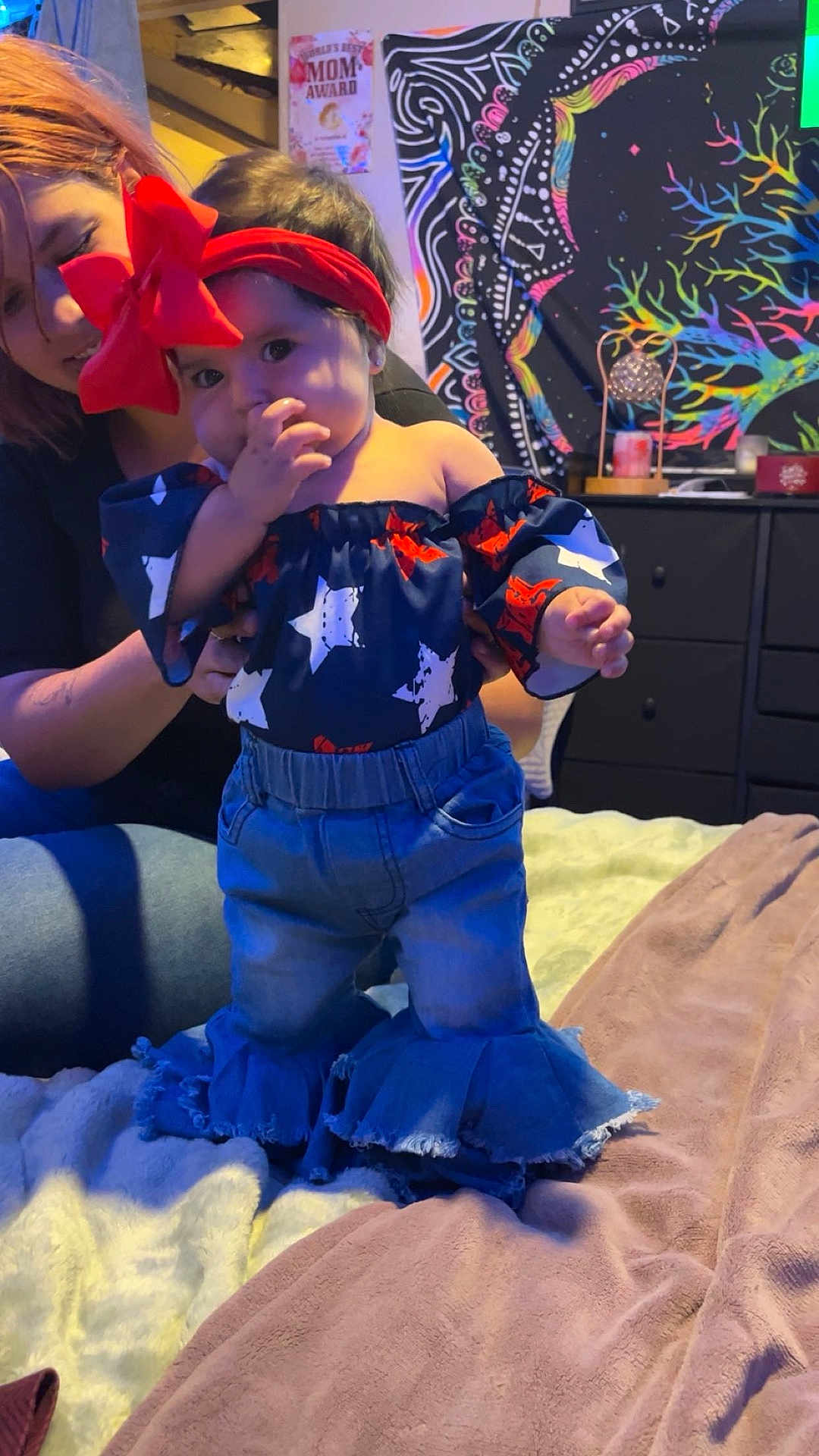 Melonie Me-Lon-e joined the competition — help win amazing prizes! toddler, child, adult, bed, headband, red_bow, jeans, off_shoulder_top, stars_pattern, colorful_tapestry, award_poster, furniture, indoor, person, supporting_hand, blanket, home, smiling, cute, cozy