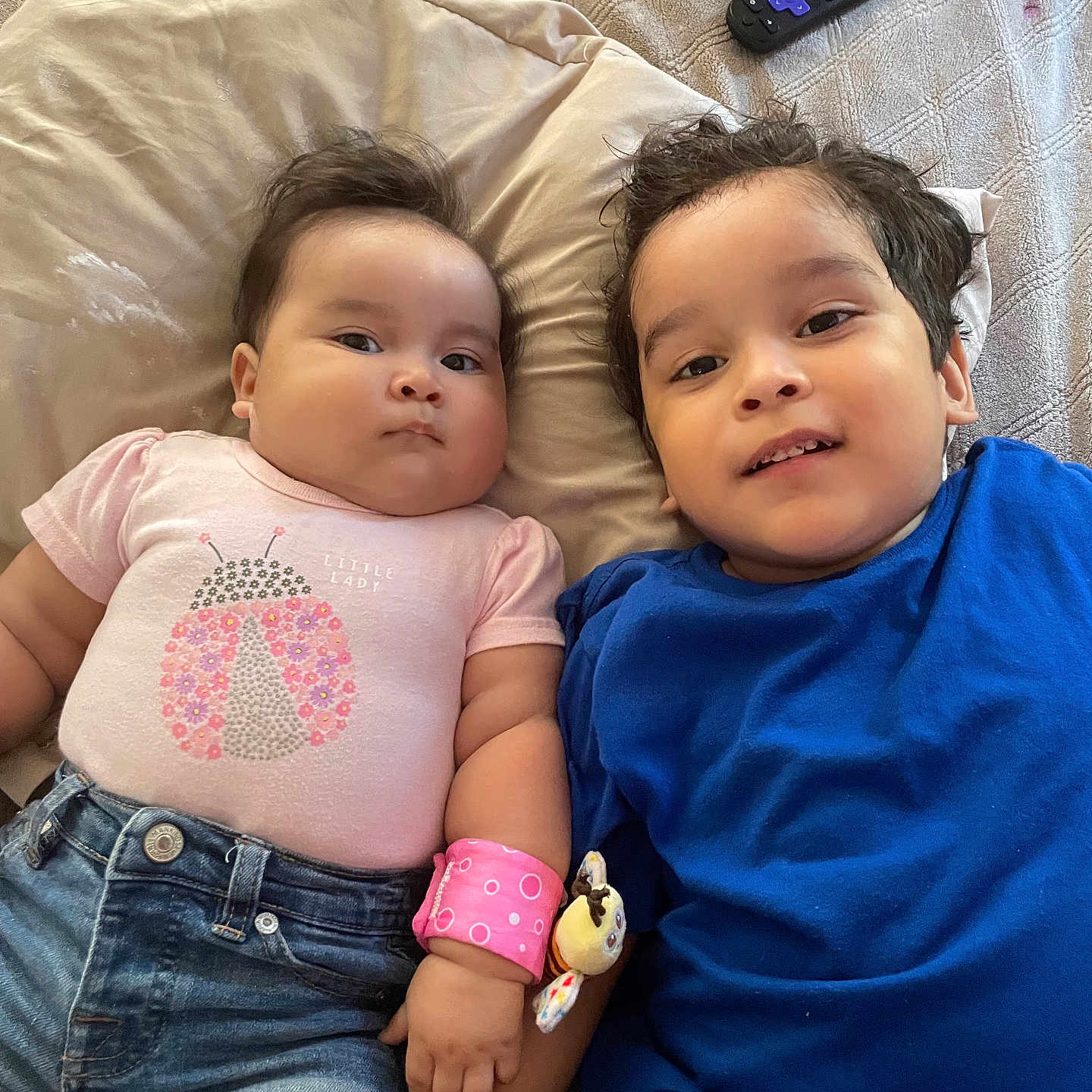 Madeline Galarza joined the competition — help win amazing prizes! baby, bed, blue, bracelet, child, clothing, cute, denim_shorts, face, hair, indoor, pillow, pink, plush_toy, relaxed, remote_control, sibling, smile, toddler, tshirt
