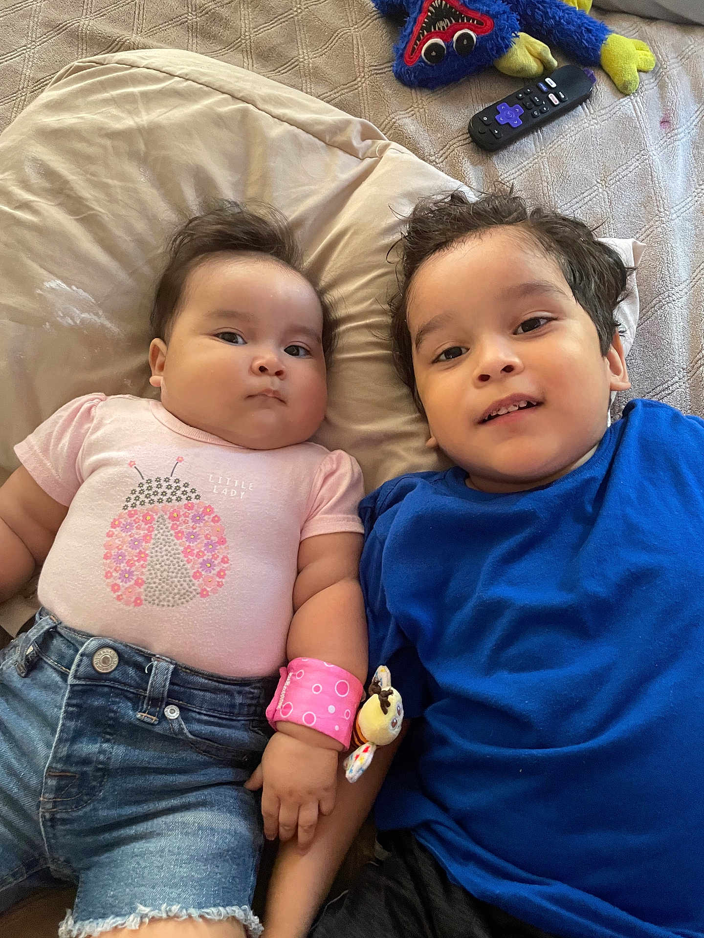 Madeline Galarza joined the competition — help win amazing prizes! child, baby, toddler, sibling, bed, pillow, plush_toy, remote_control, clothing, denim_shorts, tshirt, pink, blue, bracelet, cute, indoor, relaxed, smile, face, hair