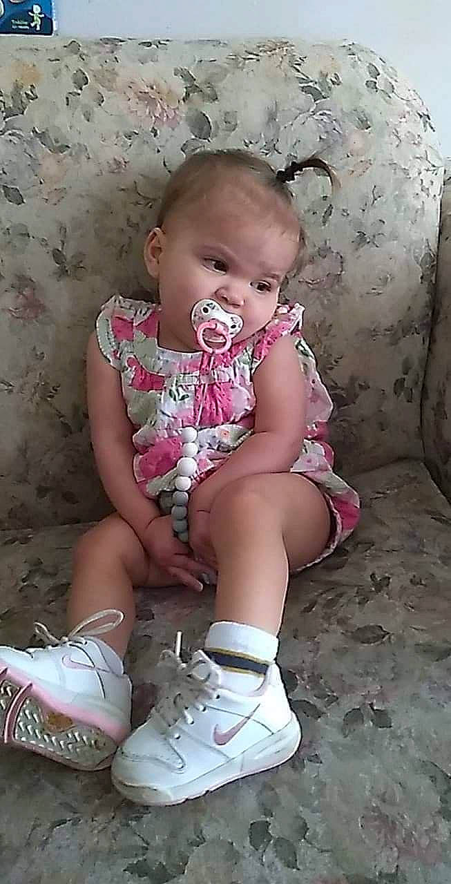 Thalia is registered to the contest to win money with this photo: arm, baby_toddler_clothing, cheek, child, comfort, eye, finger, hairstyle, head, knee, leg, mouth, person, pink, shoe, skin, sleeve, sock, thigh, toddler