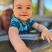 Arthur a rejoint le concours — aidez-le/la à gagner de superbes lots ! arm, baby, blue_clothing, blurred_background, child, closeup, cute, expression, face, hand, happy, metal, outdoor, person, portrait, skin, smiling, sunlight, water, young_child