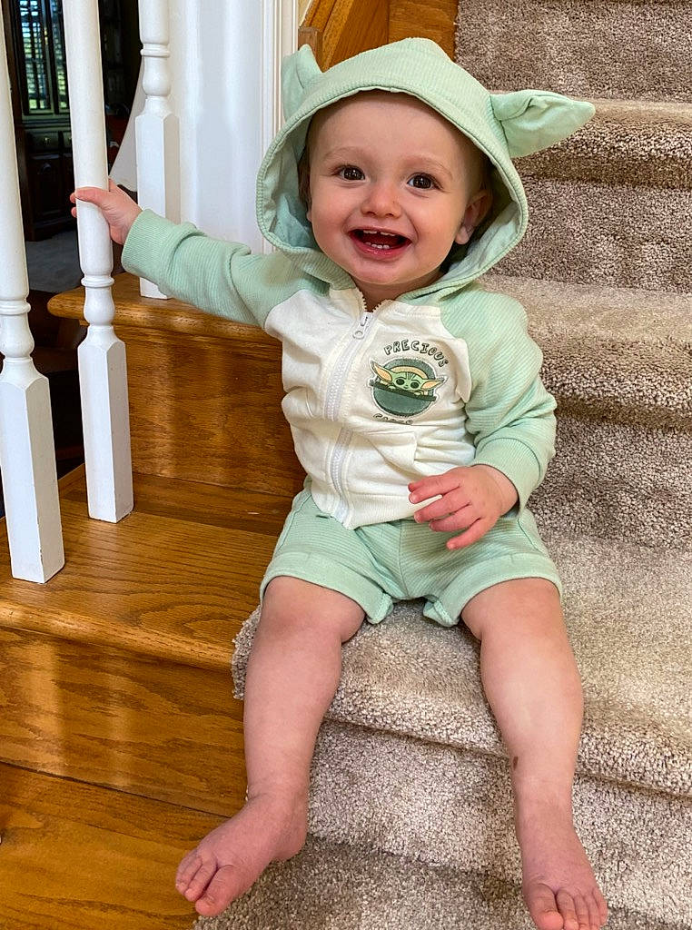 Owen is registered to the contest to win money with this photo: baby, baby_toddler_clothing, beauty, clothing, face, finger, green, happy, hat, head, headwear, human_body, joy, organ, person, photograph, skin, sleeve, smile, standing