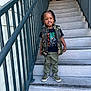 child, stairs, smiling, camouflage, vest, tshirt, pants, shoes, outdoor, railing, concrete, person, fashion, happy, portrait, hair, braids, casual, footwear, daylight
