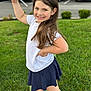 Sophie is registered to the contest to win money with this photo: child, girl, smiling, white_tshirt, navy_skirt, long_hair, outdoor, grass, greenery, parking_lot, cars, playful_pose, happy, person, young, casual_clothing, daylight, holding_object, background_blur, nature