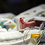 newborn, foot, hospital, blanket, medical_equipment, tube, infant, bed, healthcare, patient, closeup, skin, baby, care, soft, tiny, premature, fragile, white, nursery