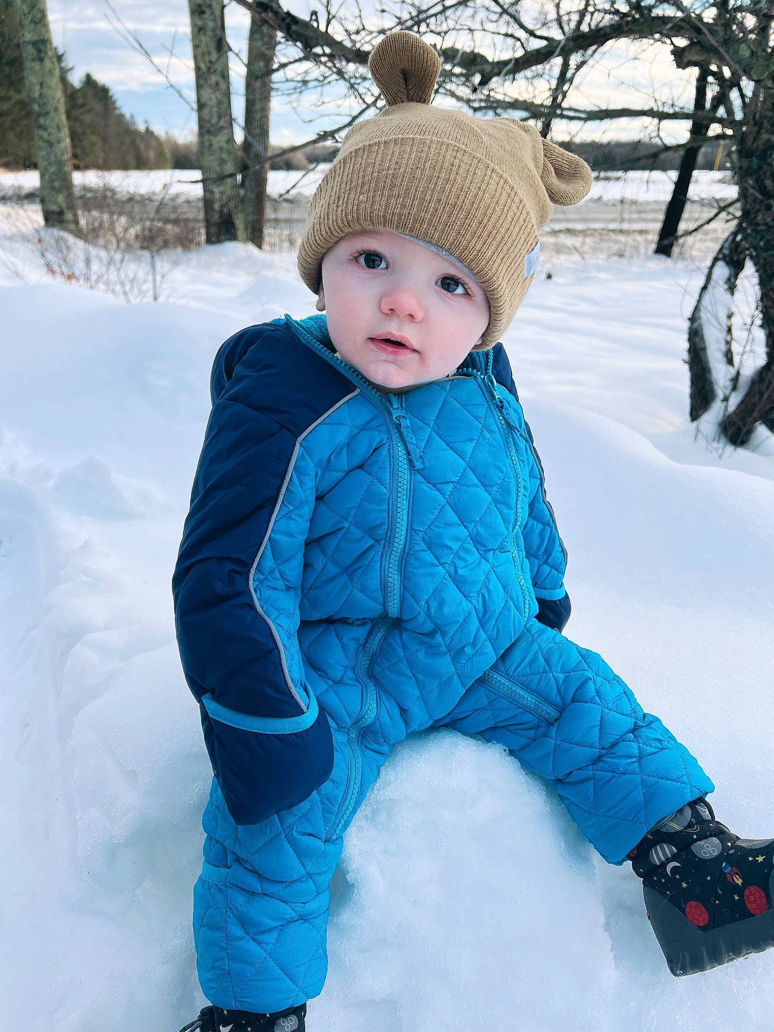 Karson is registered to the contest to win money with this photo: baby, baby_toddler_clothing, cap, cheek, child, electric_blue, freezing, fun, fur, headwear, jacket, knit_cap, pattern, person, photograph, recreation, sleeve, snow, toddler, tree