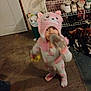 Bella joined the competition — help win amazing prizes! toddler, child, pink_hat, animal_hat, pajamas, bottle, drinking, indoor, door, shoes, shoe_rack, floor, carpet, clothing, baby, footwear, toy, standing, blur, childwear