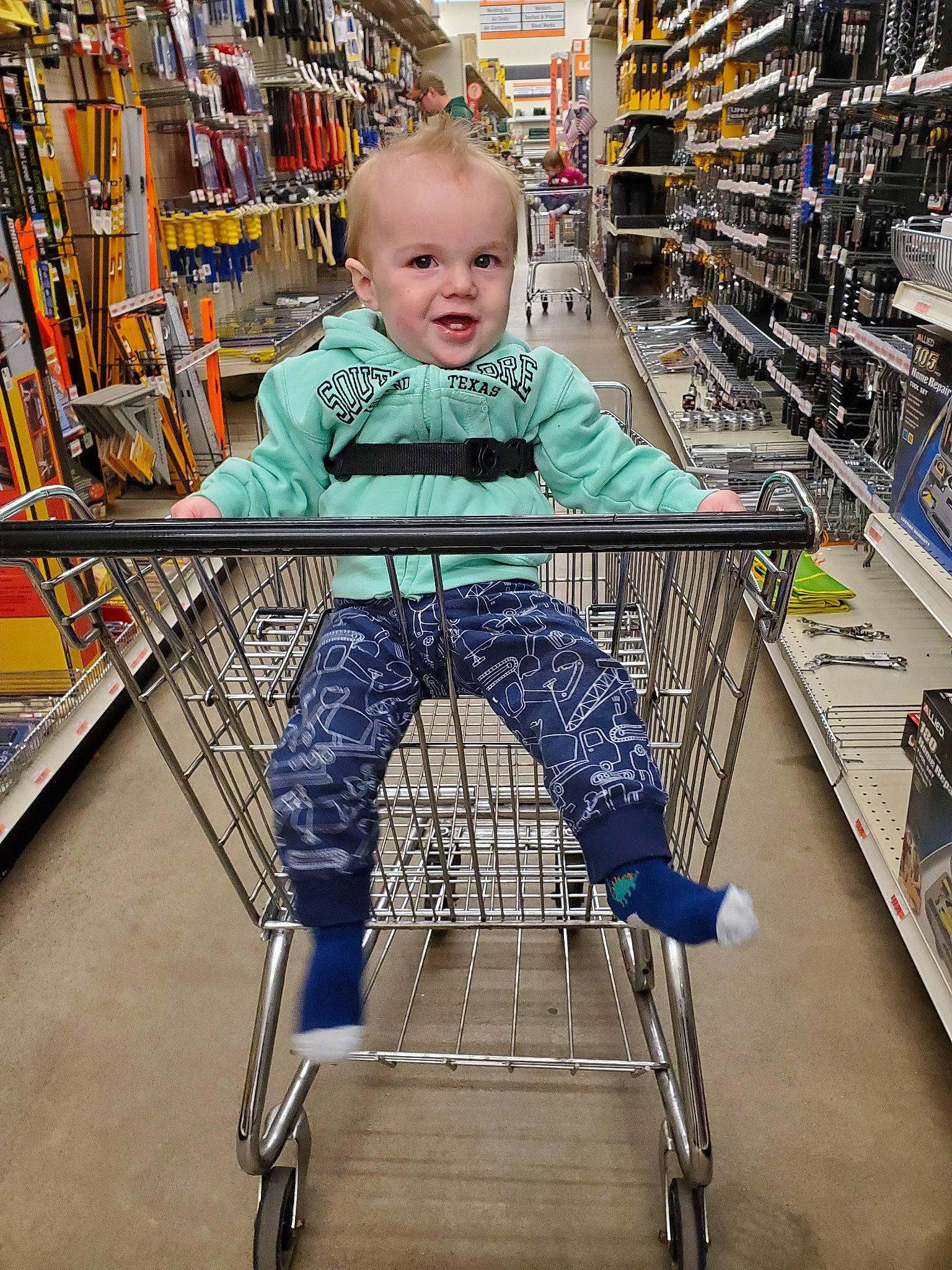 Caiden Ennis is registered to the contest to win money with this photo: aisle, cart, child, grocery_store, person, product, retail, service, shopping, shopping_cart, sitting, supermarket, toddler, vehicle
