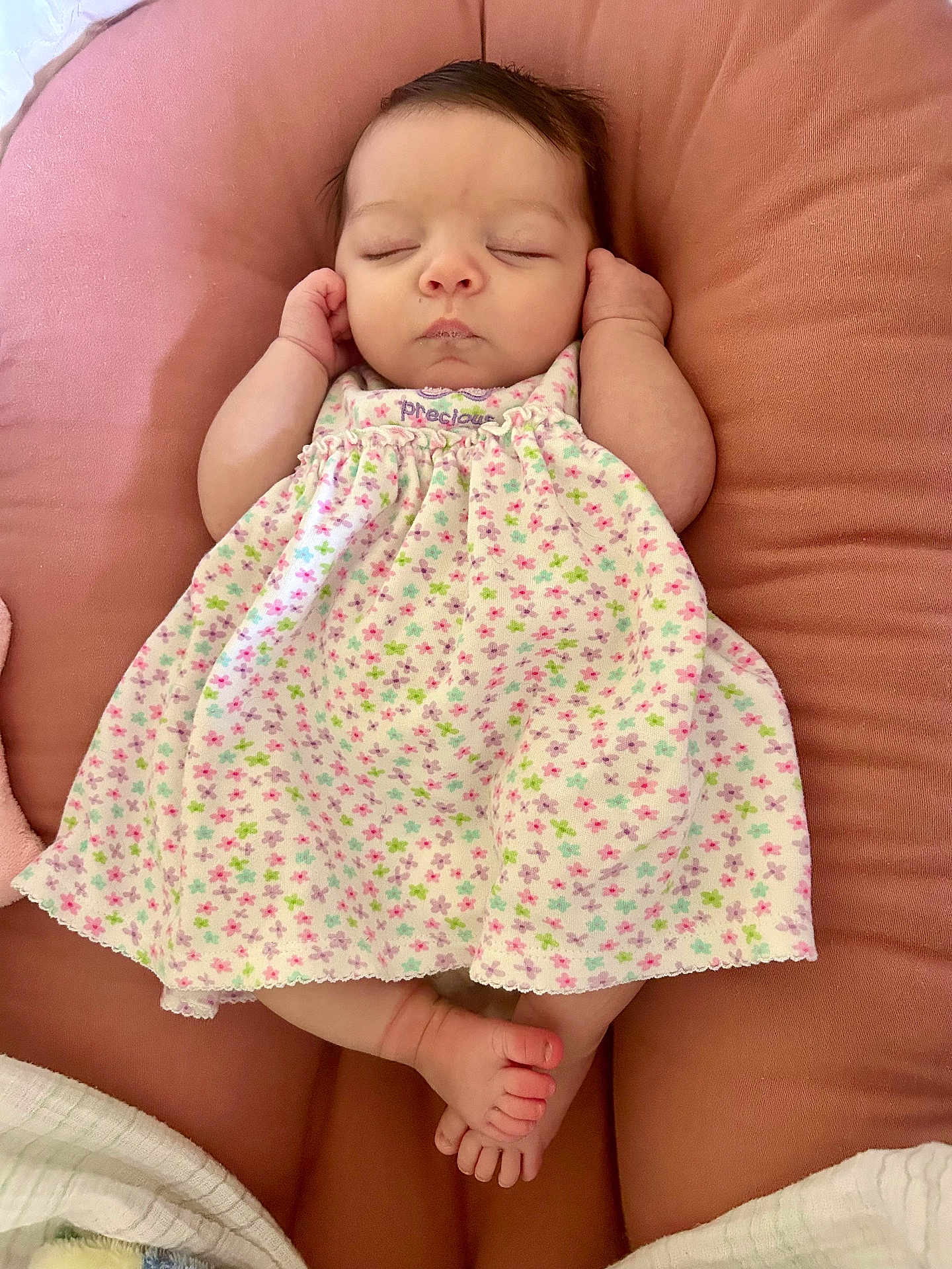 Gracie is registered to the contest to win money with this photo: baby, sleeping, infant, dress, floral_pattern, pink, cushion, hands, feet, peaceful, cute, newborn, child, portrait, resting, soft, cozy, indoors, closeup, adorable