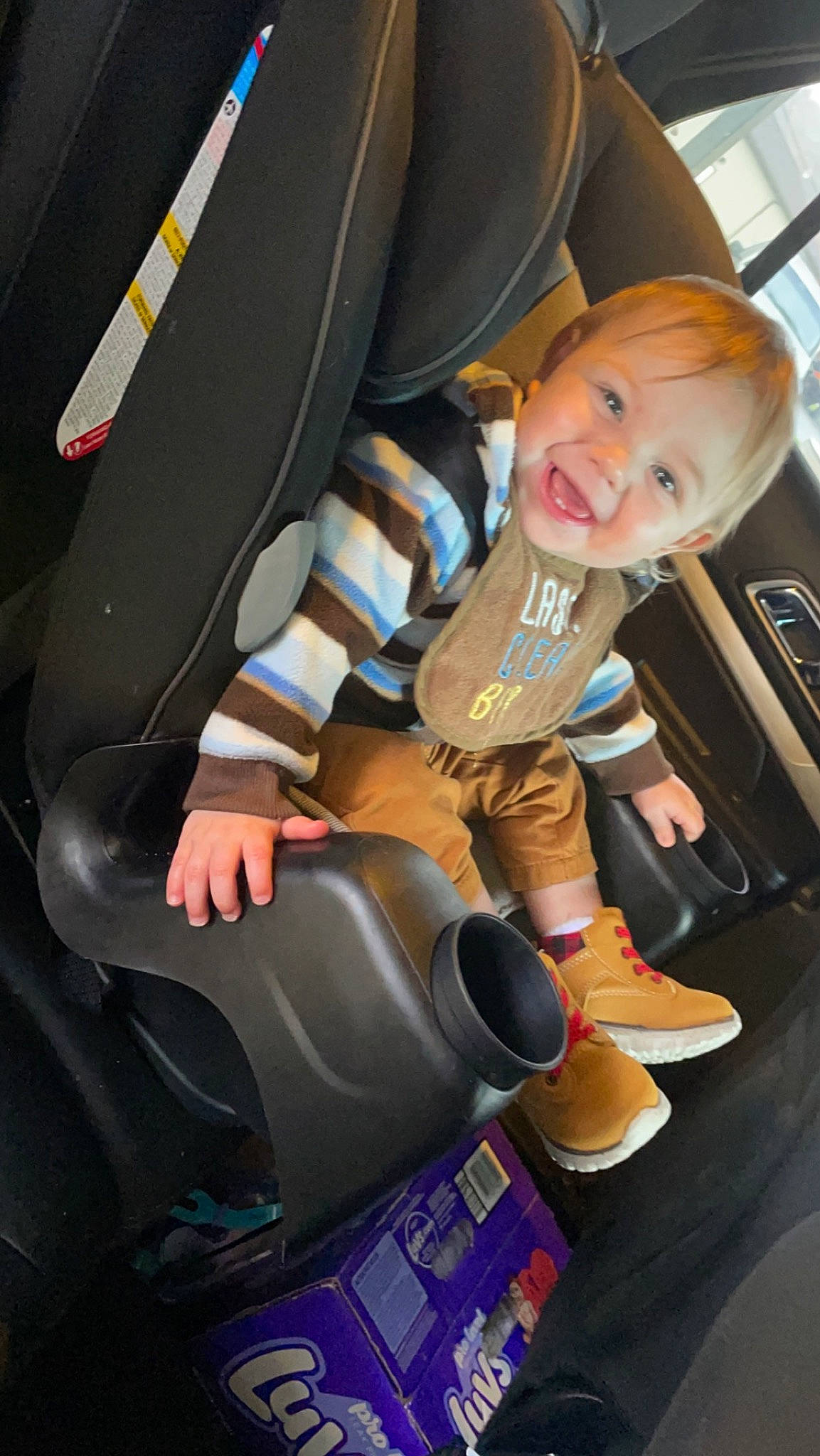 Mason is registered to the contest to win money with this photo: auto_part, automotive_design, automotive_exterior, automotive_tire, baby_products, car_seat, car_seat_cover, child, comfort, family_car, fun, joy, leg, luxury_vehicle, motor_vehicle, person, sitting, smile, steering_wheel, toddler