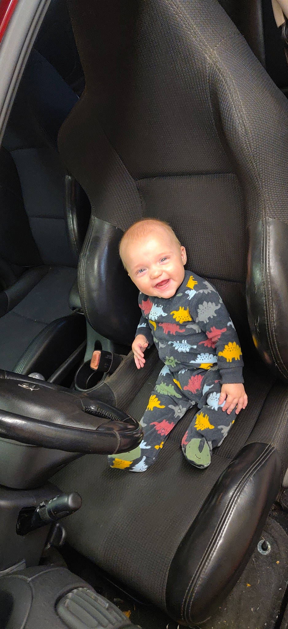 Lydia is registered to the contest to win money with this photo: auto_part, automotive_design, automotive_exterior, automotive_tire, car, car_seat, car_seat_cover, child, comfort, family_car, head_restraint, mode_of_transport, motor_vehicle, person, sitting, smile, steering_part, tints_and_shades, toddler, vehicle