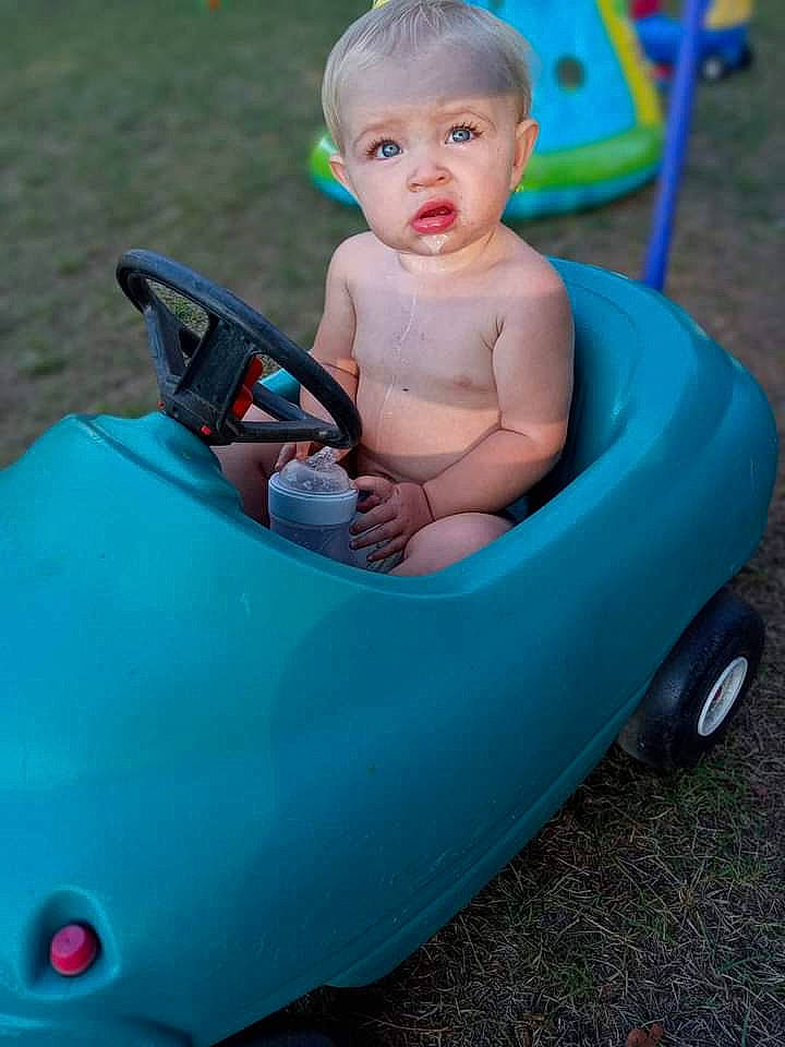 Ansley is registered to the contest to win money with this photo: aqua, baby, baby_products, baby_toddler_clothing, bathing, child, electric_blue, fun, grass, happy, leisure, person, photograph, plastic, play, product, recreation, riding_toy, sitting, toddler