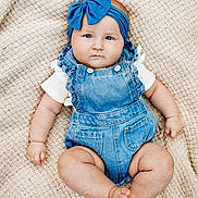 Lakelyn is registered to the contest to win money with this photo: baby, infant, child, portrait, lying_down, blanket, woven_texture, blue_headband, bow, denim_overalls, white_shirt, fashion, indoors, closeup, face, eyes, serious_expression, sitting_pose, cozy, photography