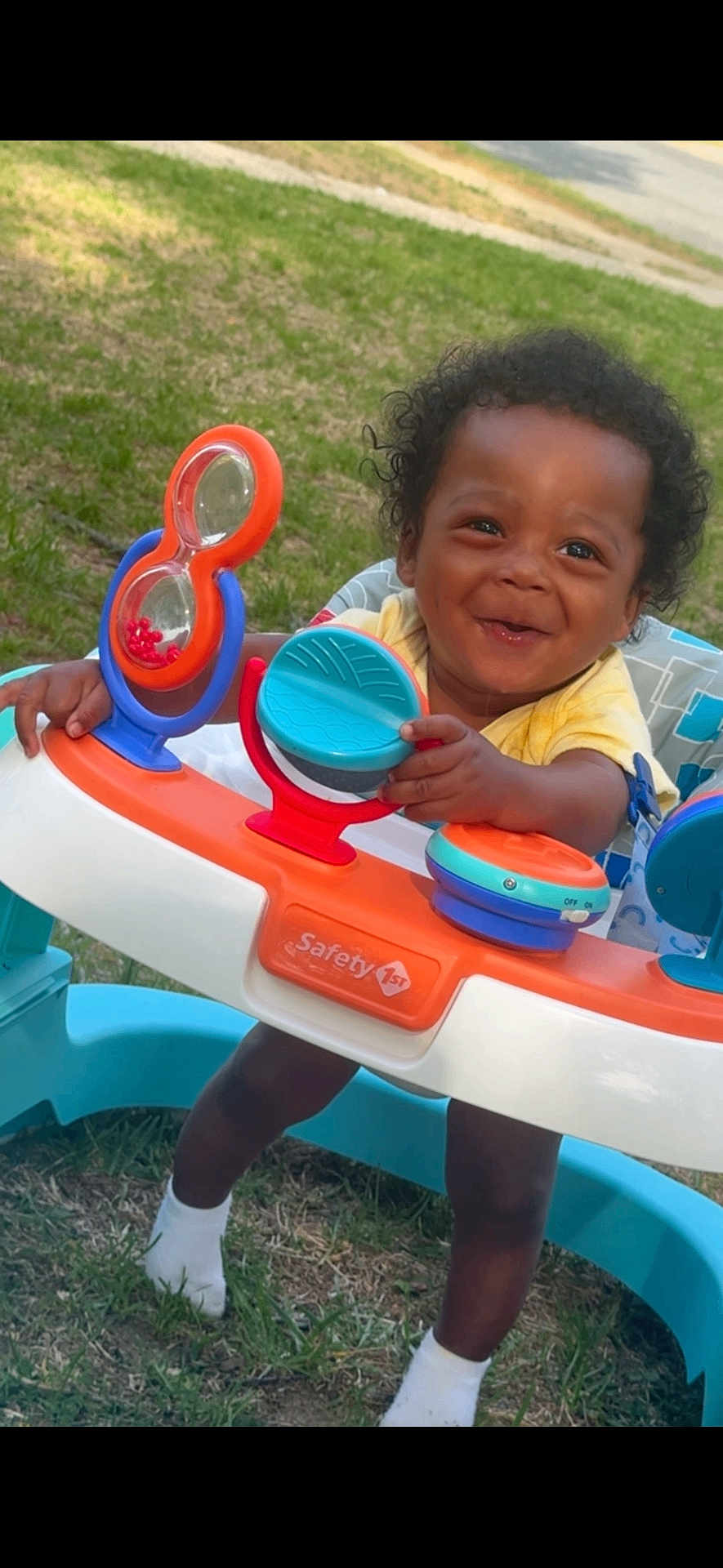 Zhyeed is registered to the contest to win money with this photo: toddler, baby, child, smiling, walker, toy, outdoor, grass, curly_hair, yellow_shirt, white_socks, playtime, happy, person, infant, cute, baby_walker, childhood, fun, daylight