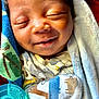Zhyeed is registered to the contest to win money with this photo: baby, newborn, smiling, blanket, pacifier, soft_toy, sleeping, wrapped, cute, infant, face, closeup, child, resting, indoors, cozy, warm, peaceful, mammal, person