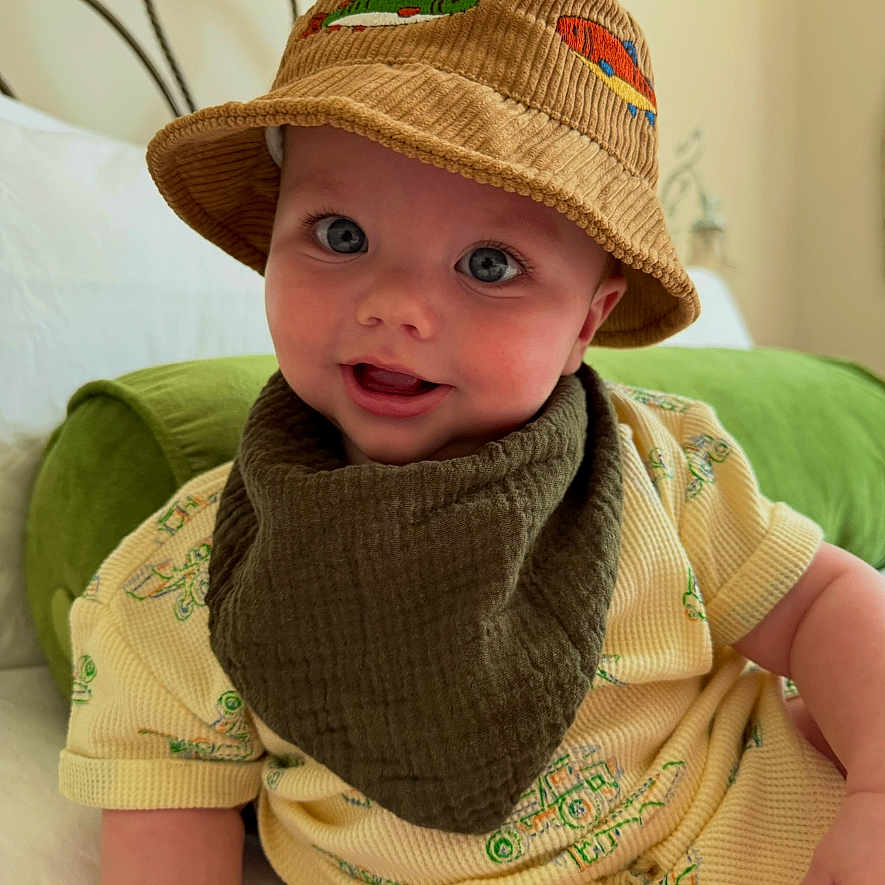 Rivian is registered to the contest to win money with this photo: baby, beanie, bodypart, bonnet, cap, clothing, couch, face, finger, furniture, hand, hat, head, knitwear, person, photography, portrait, sitting, sunhat, sweater