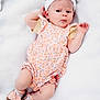 baby, infant, child, romper, headband, bow, pink, floral, blanket, footwear, socks, lying_down, cute, portrait, soft_texture, white_background, small_hands, small_feet, expression, indoors
