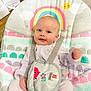 baby, infant, smiling, baby_seat, rainbow, sun, cloud, floor, wooden_floor, straps, clothing, cute, child, happy, indoors, person, seat, baby_toys, colorful, bright