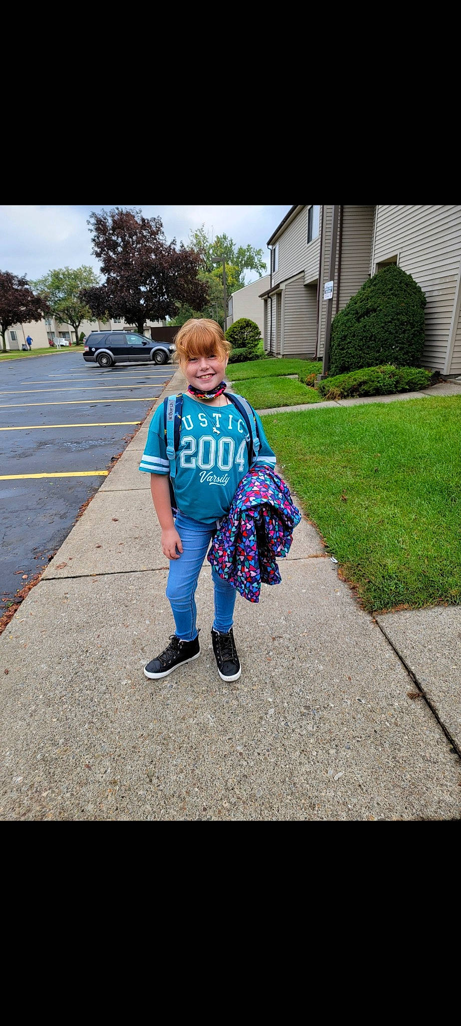 Nevaeh is registered to the contest to win money with this photo: asphalt, car, denim, electric_blue, family_car, grass, joy, leisure, pedestrian, person, plant, recreation, road, road_surface, rolling, sidewalk, sky, t_shirt, toddler, tree