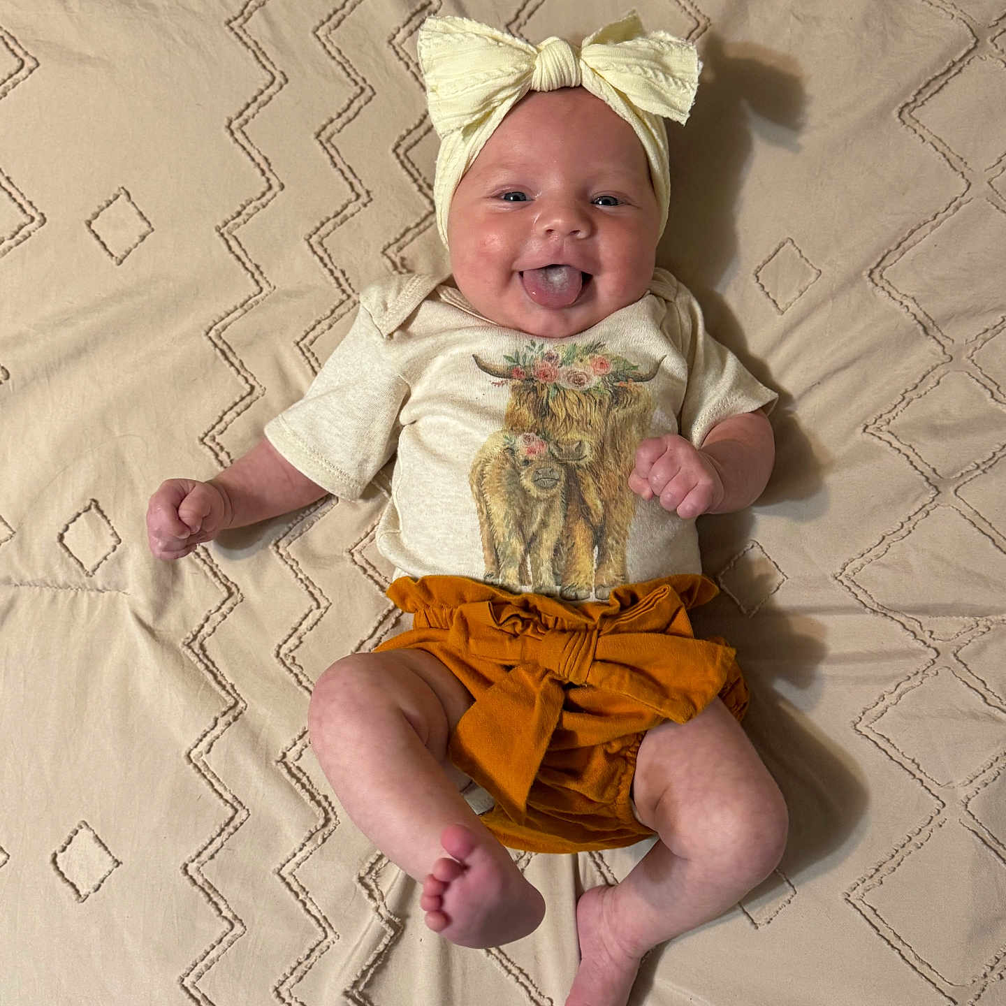 Kambrie joined the competition — help win amazing prizes! animal_print, baby, beige_blanket, bow, child, cow, cute, flower_crown, happy, headband, infant, lying_down, mustard_color, playful, portrait, shirt, shorts, smiling, textured_blanket, tongue_out